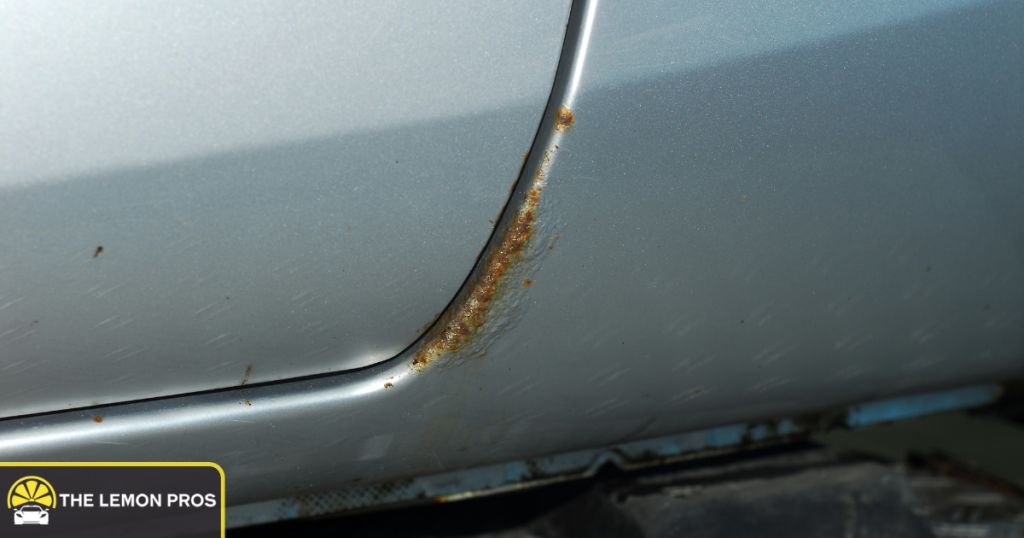 Rust penetration on a vehicle body panel illustrating corrosion perforation covered under warranty